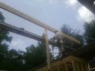 Carpenter setting a ridge beam over a new addition frame — Ice Dam Removal by Roofing Brothers in Franklin Square