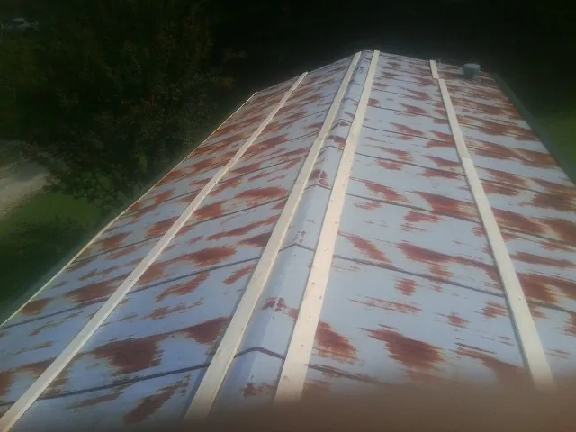 Rusted metal roof panels with new wood purlins before replacement — Storm Damage Roof Repair in Franklin Square by Roofing Brothers