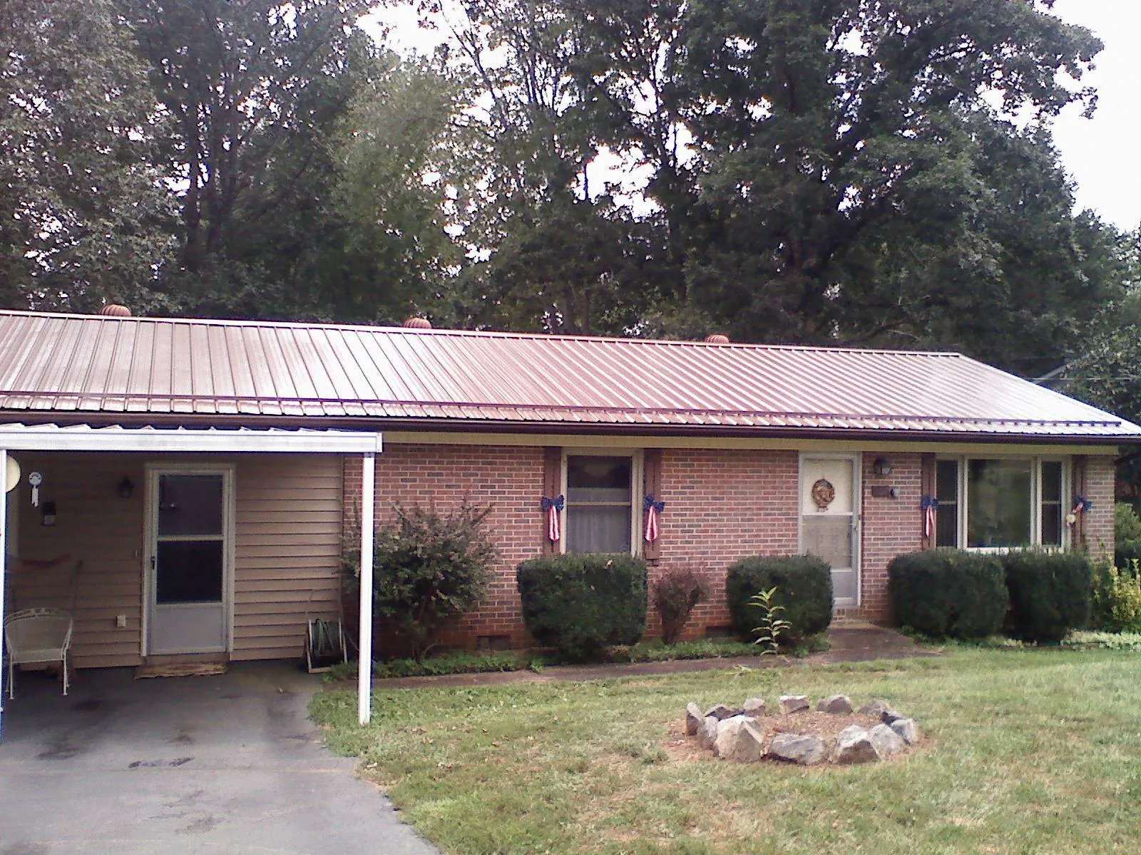 Bronze metal roof and carport on a brick ranch home — Roof Repair work by our crew in Franklin Square